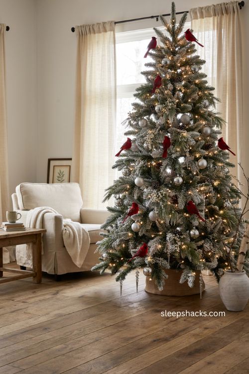 Cardinal ornaments on a white and silver Christmas tree with snowy woodland charm 