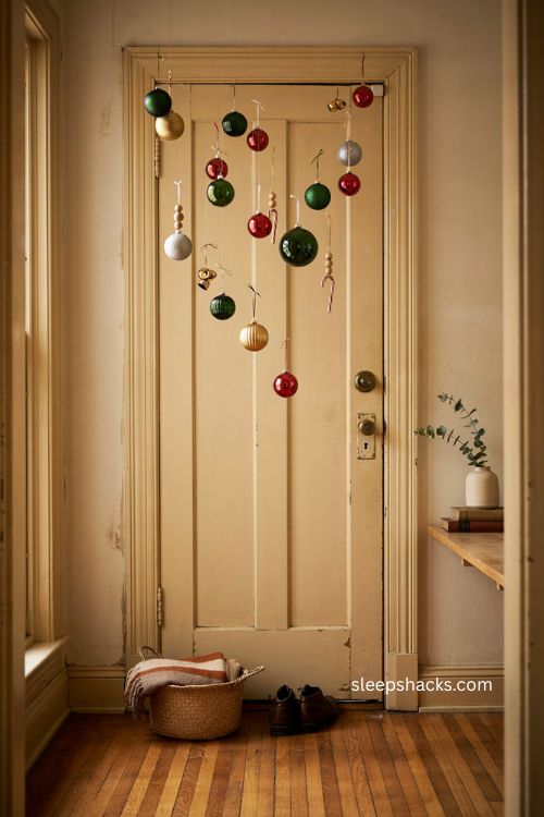 Cascading christmas ornaments on apartment door with vintage baubles bells and candy canes 