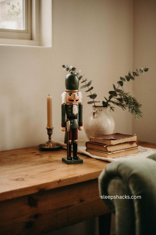 Christmas figurine decor with a nutcracker books and vintage vase 