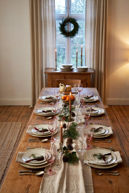Christmas table decor with neutral dinnerware greenery and red ribbon 