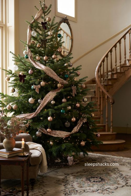 Christmas tree garland with sequined ribbon and coordinated ornaments by a staircase 