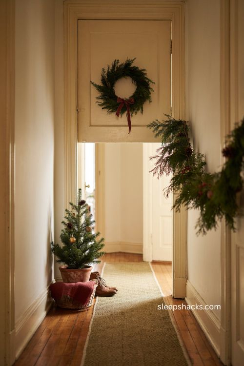 Coordinating apartment door and hallway christmas decor with mini tree runner rug and garland 