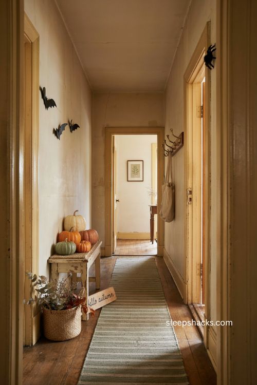 Cozy Halloween hallway with subtle witch decor farmhouse bench and layered pumpkins