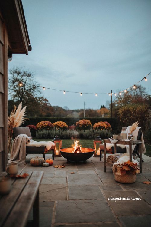 Cozy Thanksgiving outdoor seating nook with firepit chairs sheepskin throws and drinks trolley