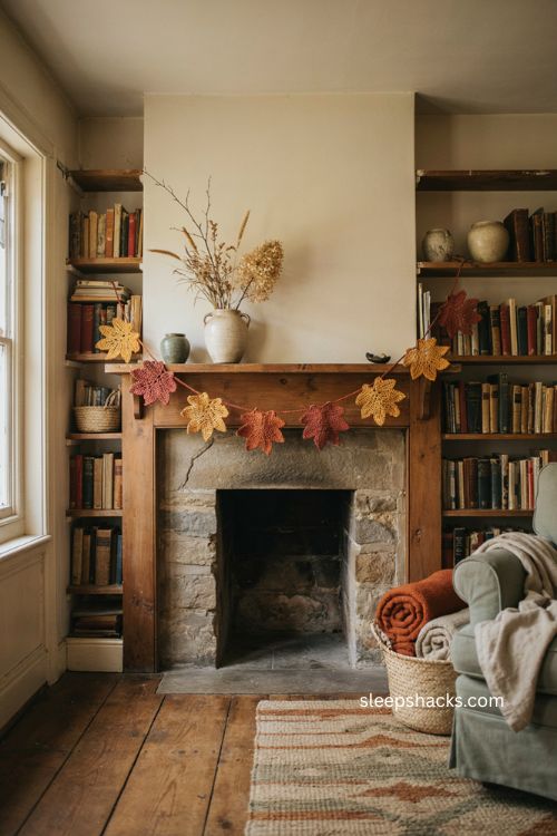 Crochet fall leaf garland in red orange and yellow on a cozy autumn bookshelf mantel
