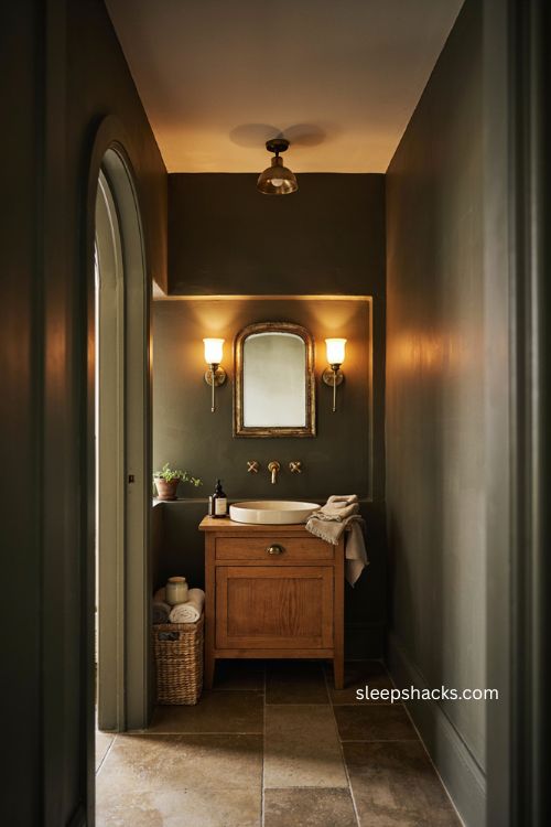 Dark warm moody bathroom with wood vanity brass fixtures soft lighting and cozy retreat style 