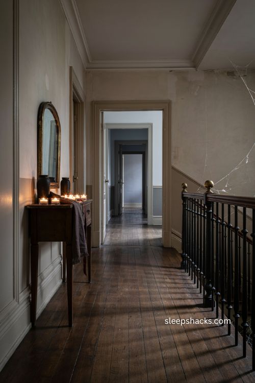 Elegant minimalist Halloween hallway with dark trim spiderwebs and candlelight 