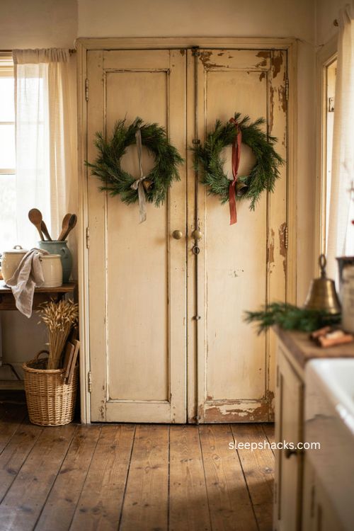 Farmhouse Christmas kitchen pantry doors with wreaths and vintage bells