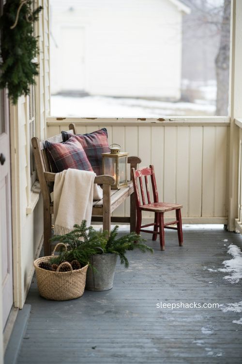 Farmhouse Christmas porch with vintage child size chair and greenery 