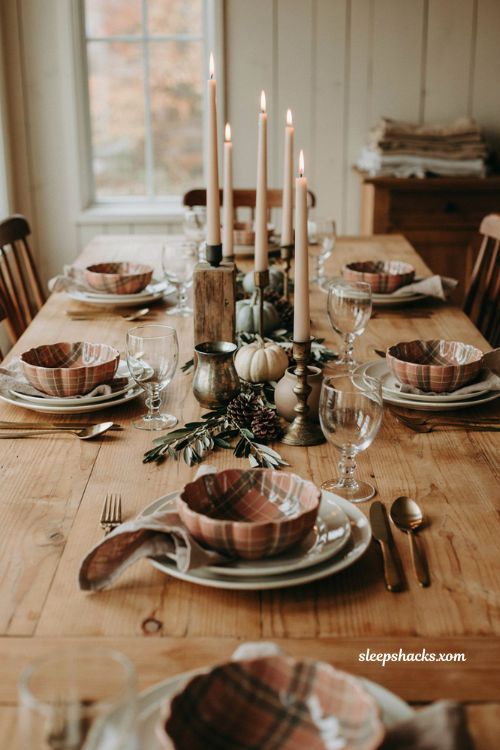 Farmhouse Thanksgiving tablescape with plaid pumpkin bowls and rustic candles