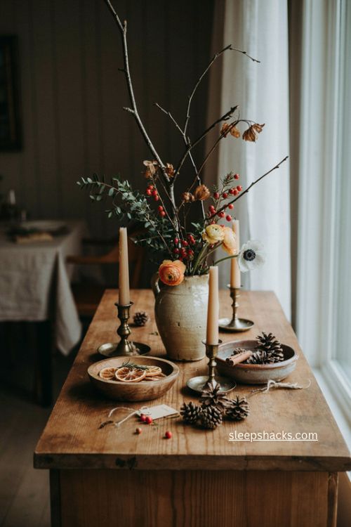 Foraged foliage Christmas sideboard decor with seasonal orange and crimson flowers