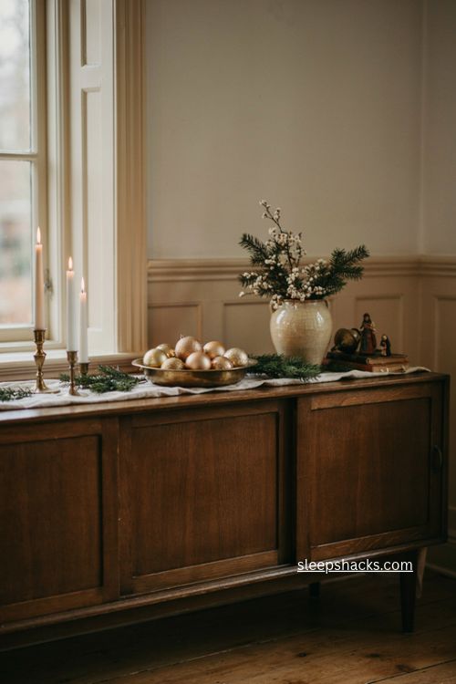 Gold and white Christmas sideboard decor with pine and vintage brass
