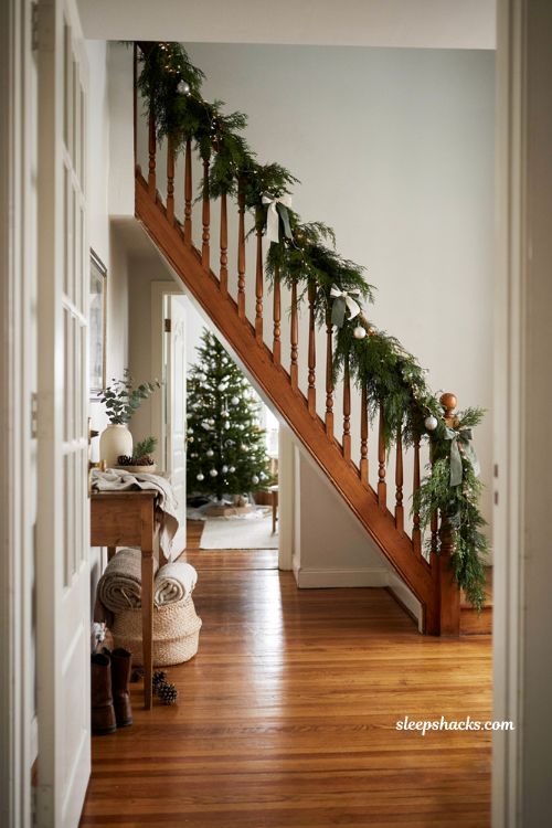 Green Christmas decor ideas with banister garland bows and silver orbs