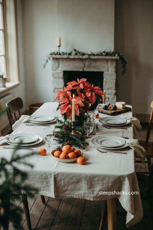 Green Christmas table with compact poinsettia centerpiece pine branches and pinecones