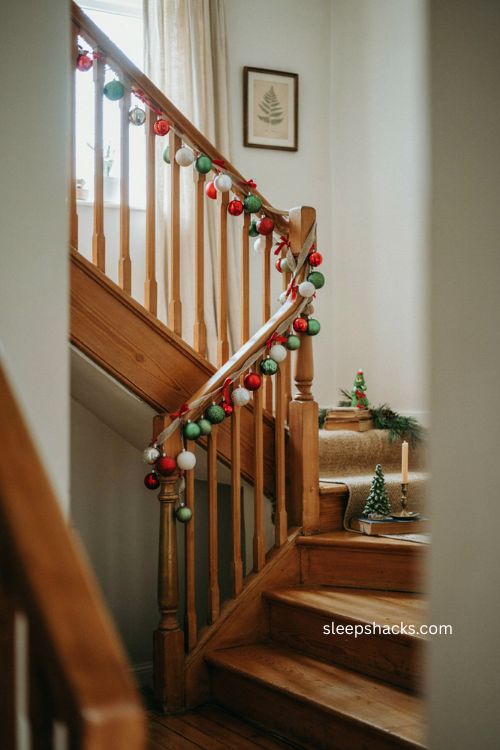 Grinch ornament garland with green red white ornaments and red bows on stairs
