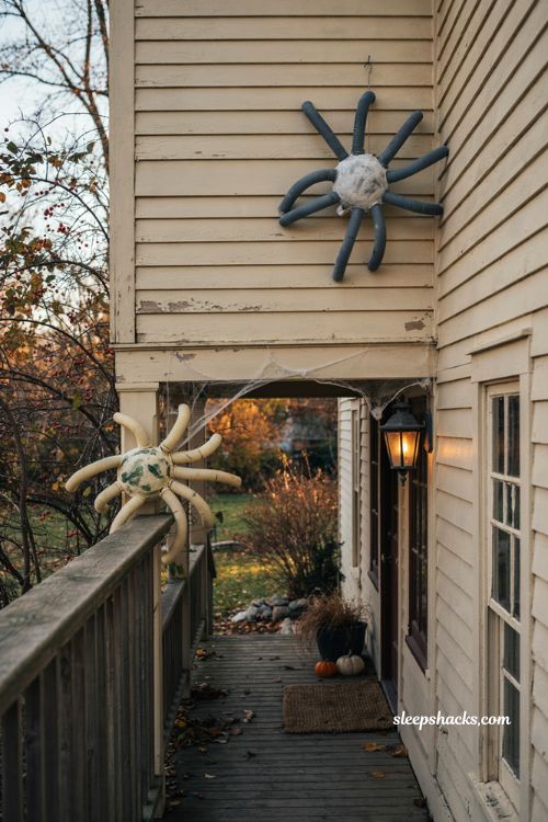 Halloween garden ideas with giant diy spiders climbing the house and porch
