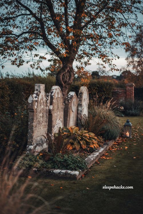 Halloween garden ideas with weathered tombstones moss and spooky tree decor