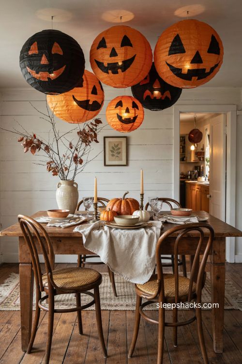 Halloween paper lanterns with jack o lantern faces and cozy dining room glow 