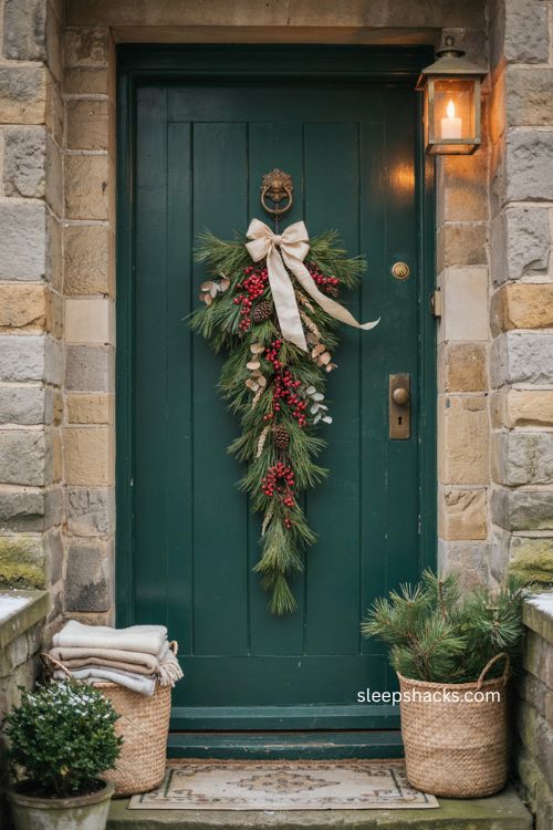 Handcrafted Christmas door swag with pine branches red berries and ribbon bow