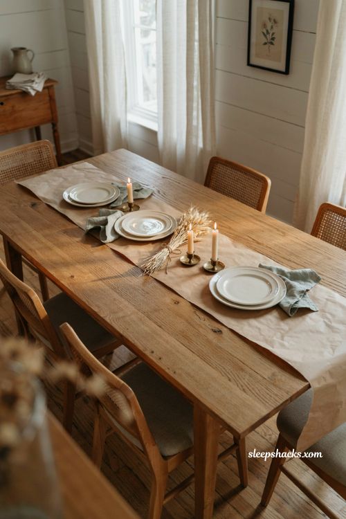 Kraft butcher paper runner on a bare wood farmhouse Thanksgiving table with candles and pumpkins 