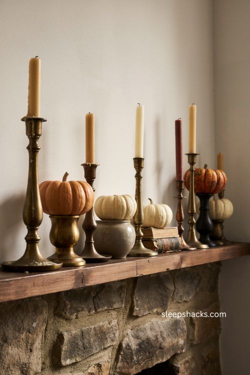 Layered brass candlesticks with pumpkins on a vintage fall mantle 