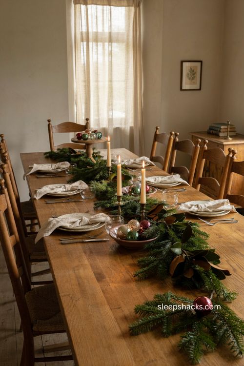 Low Christmas table centerpiece with greenery candles and vintage ornaments 