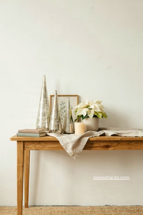 Modern christmas mercury glass trees with white poinsettia on wood console 