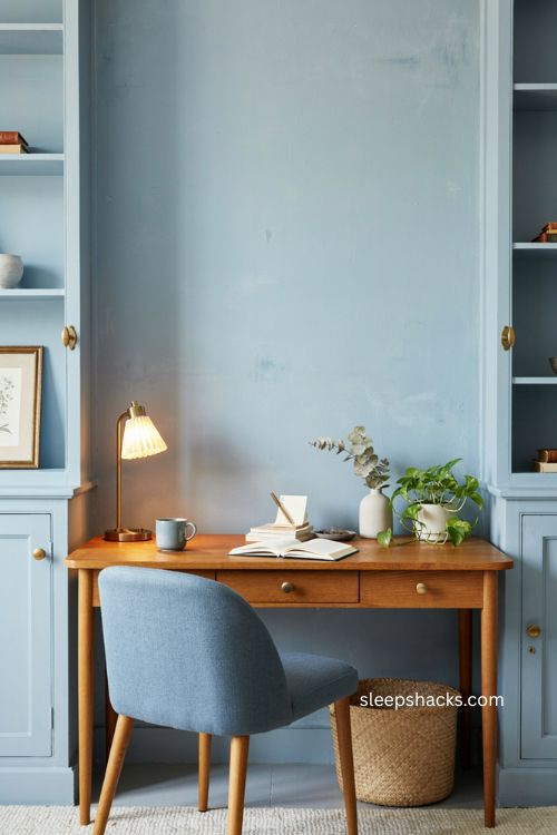Monochromatic office decor with soft blue walls and brass accents 