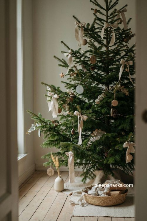 Natural linen bows on a relaxed Christmas tree with wooden ornaments and dried greenery 