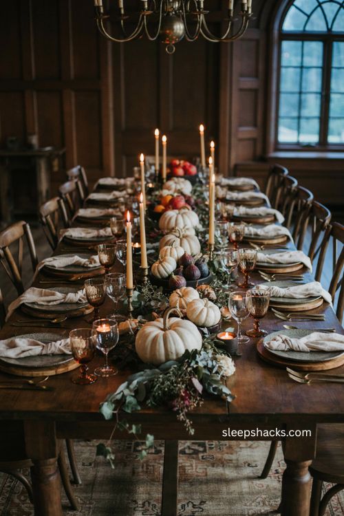 Neutral pumpkins Thanksgiving tablescape with white cream heirloom pumpkins greenery candles and moody fall decor 