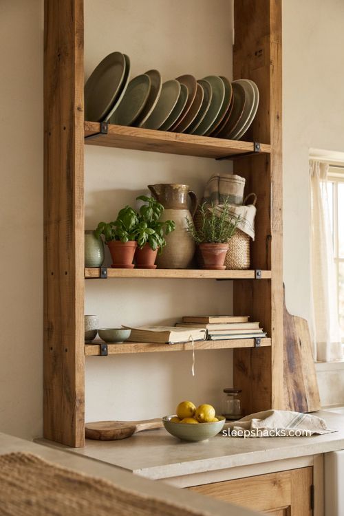 Open wood shelving with vintage ceramics and plants in a rustic kitchen 
