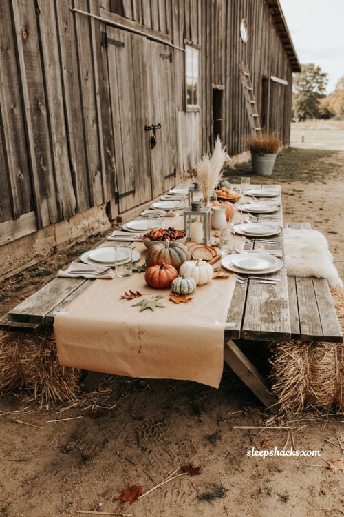 Outdoor Thanksgiving table with butcher paper runner pumpkins lanterns and rustic farmhouse decor 