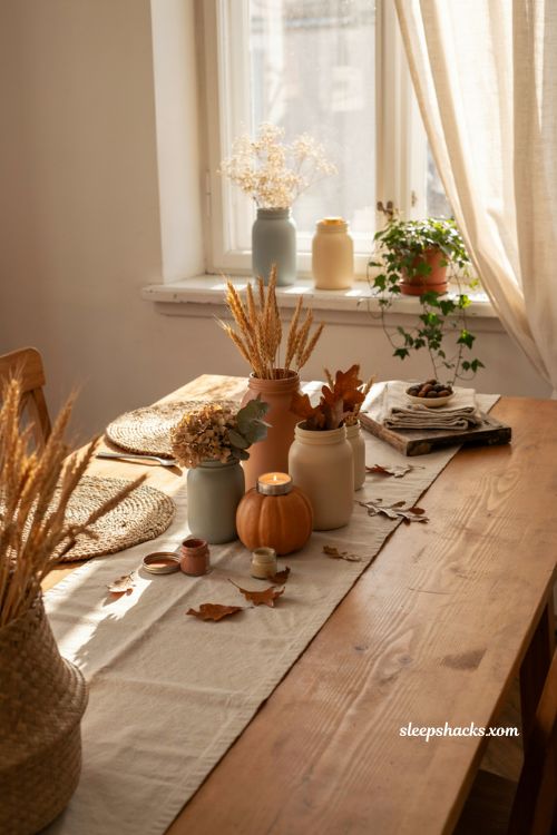Painted mason jar vases with dried flowers and cozy fall table decor 