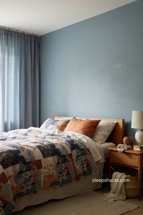 Patterned navy blue and rust bedding in a cozy small bedroom 