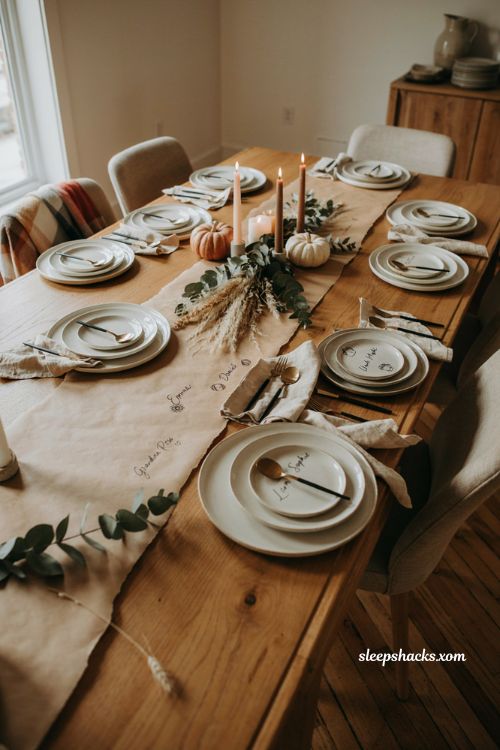 Personalized butcher paper Thanksgiving table with handwritten place names gold pen pumpkins and farmhouse decor 