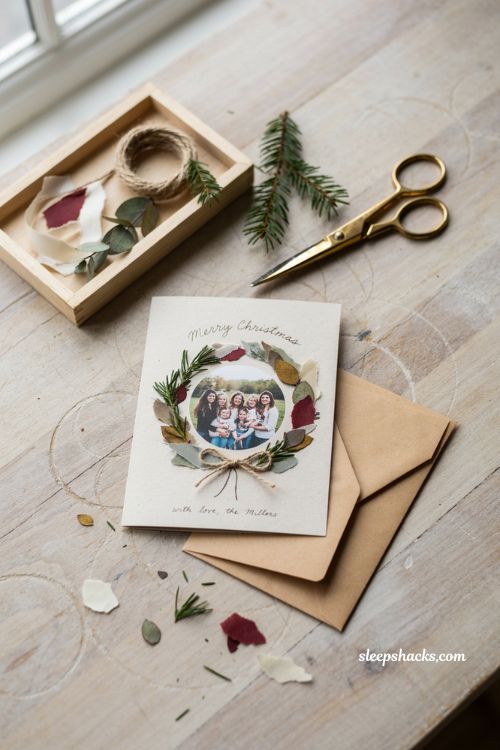 Photo wreath Christmas card ideas with dried greenery and family photo
