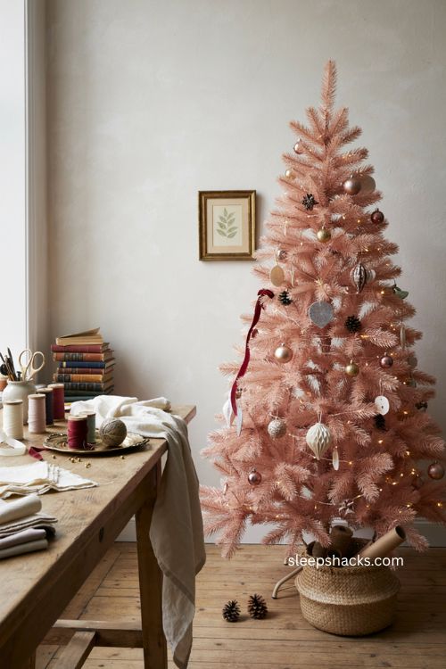 Pink 4 ft Christmas tree with metallic ornaments in a playful cozy craft room