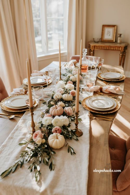 Pink and gold Thanksgiving table setting with elegant plates roses and baby pumpkins
