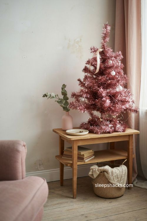 Pink tinsel Christmas tree with white lights and whimsical bedroom decor