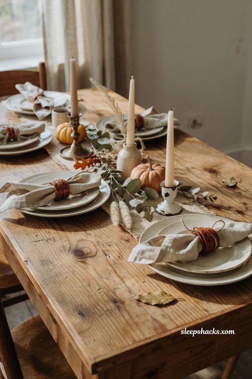 Repurposed glass jars as vases for cheap Thanksgiving table decor with greenery and dried flowers 