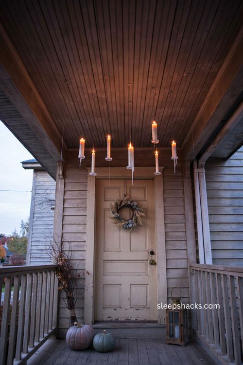Reusable command hooks for floating Halloween candles on a cozy porch ceiling 