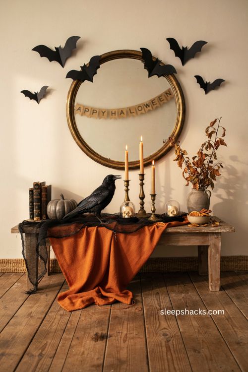 Rustic Halloween entry table with bats crows skull domes orange throw and mirror