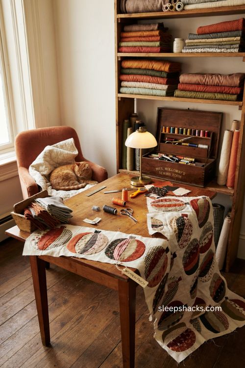 Scrappy patchwork pumpkin quilt block with orange black fabric scraps and cozy sewing room