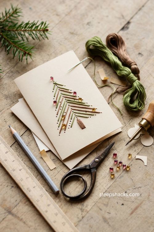 Sewn paper tree Christmas card with embroidered green thread geometric branches and festive gem details 