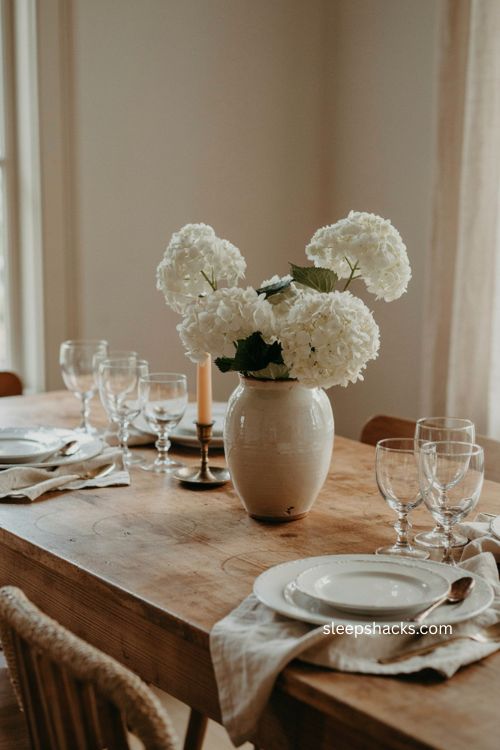 Simple Thanksgiving centerpiece with white hydrangeas in a ceramic vase