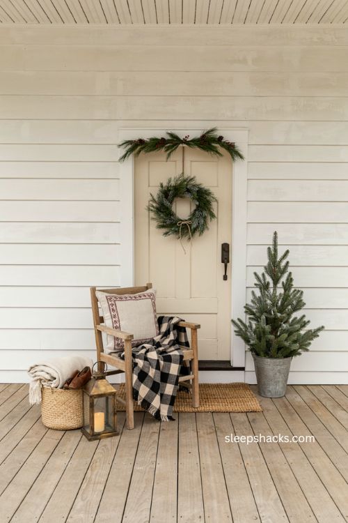 Small front porch Christmas decor with plaid throw blanket seasonal pillow and cozy chair 