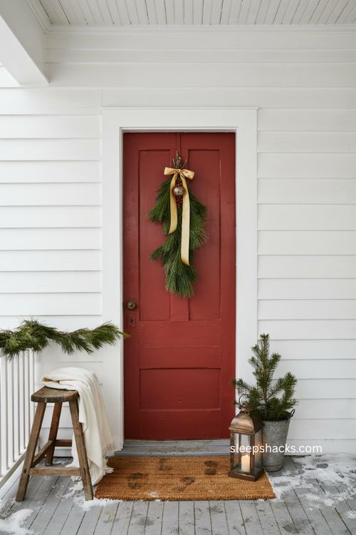 Small front porch Christmas door swag with pine branches and ribbon 