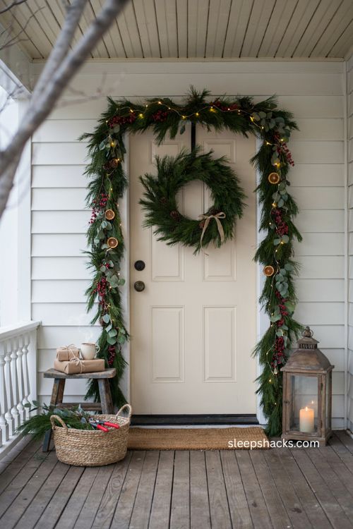 Small front porch Christmas garland with faux greenery picks berries and dried orange accents 