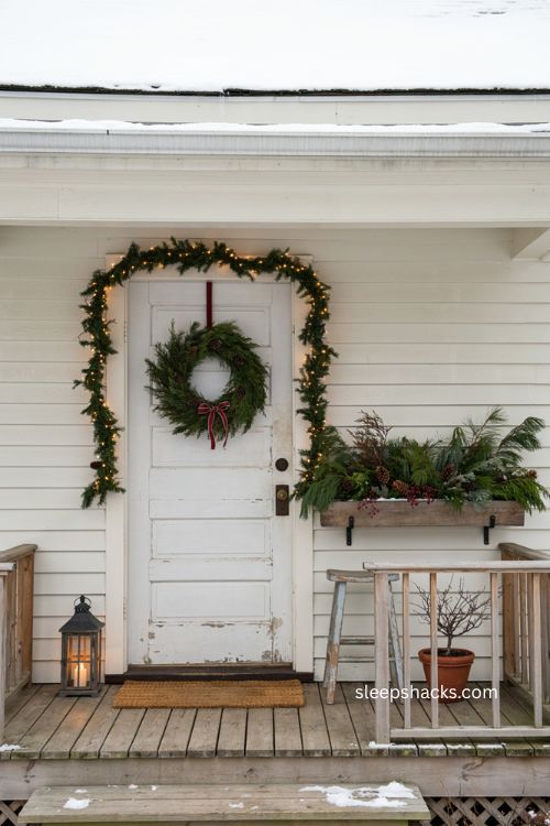 Small front porch Christmas window box greenery with pinecones and red berries 