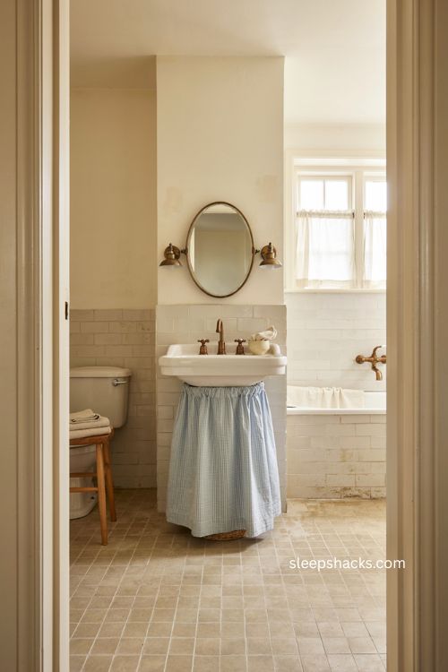 Small full bathroom with blue gingham sink skirt vintage pedestal sink and cozy charm 